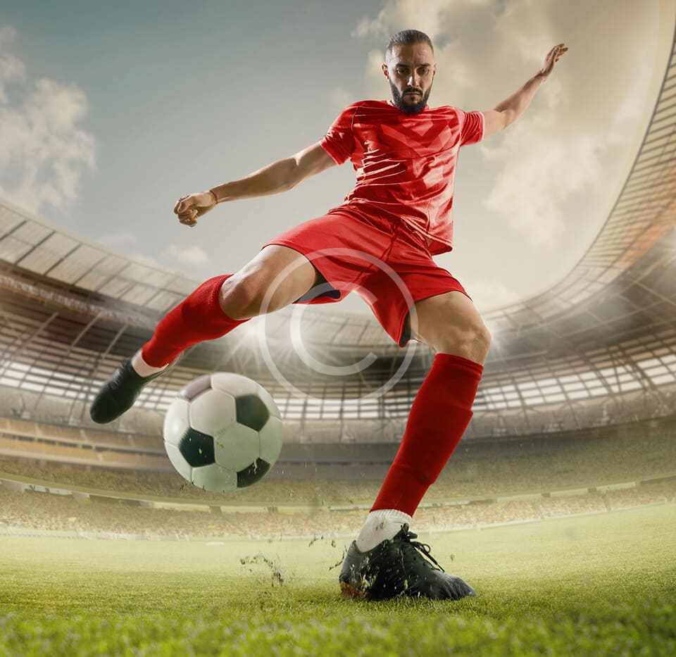 Fotbalista při střele na stadionu